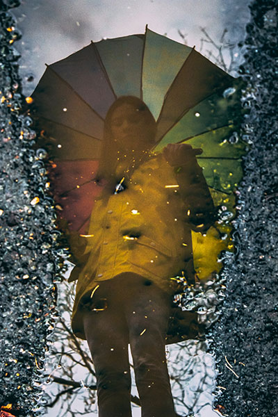 Idee fotografiche autunnali per Instagram - riflesso con in una pozzanghera con un ombrello