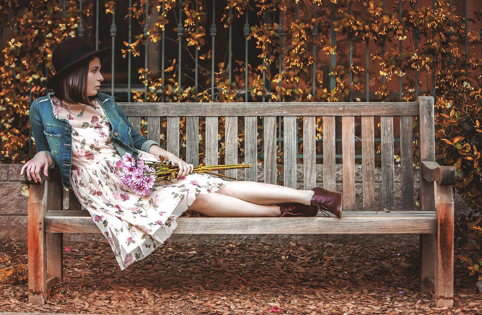 Idee fotografiche autunnali per Instagram - una ragazza su una panchina
